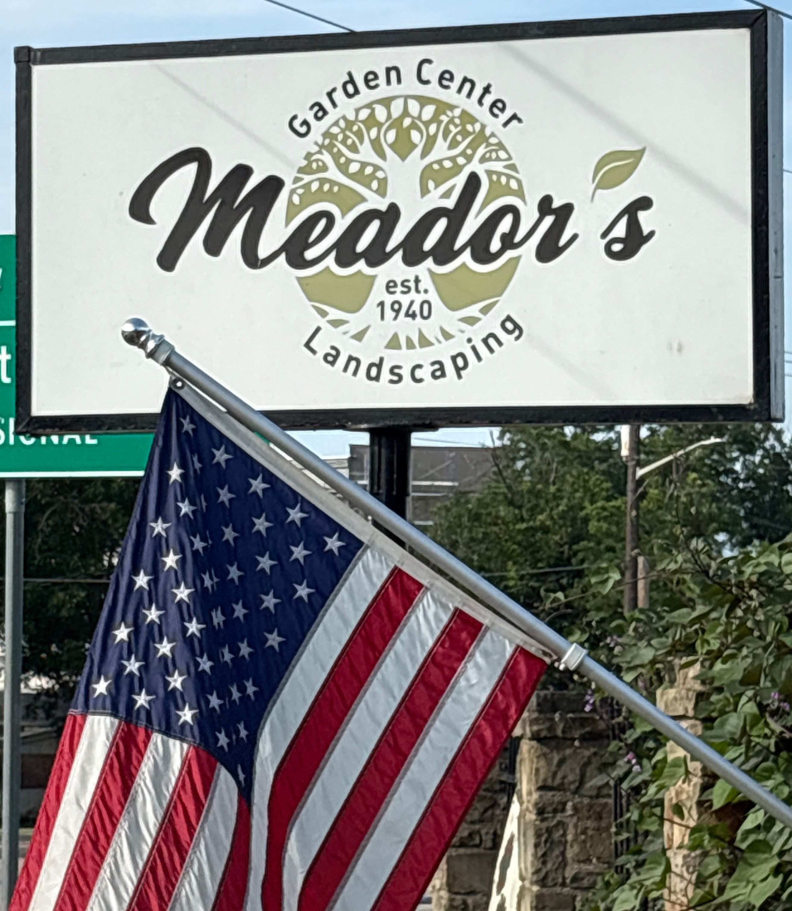 Meador Nursery front sign with Flag in foreground