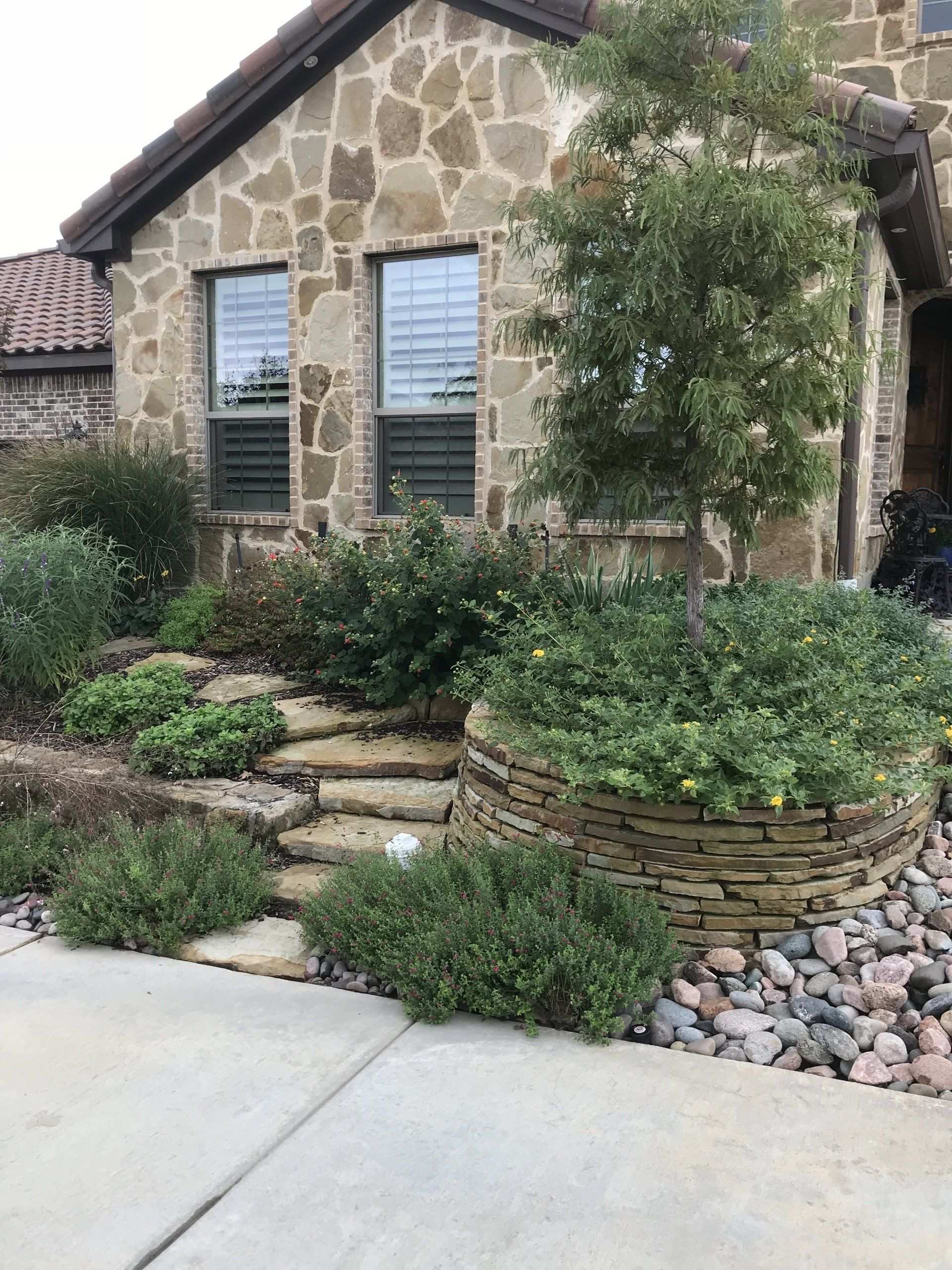 Stone path and planting bed beside a stone house
