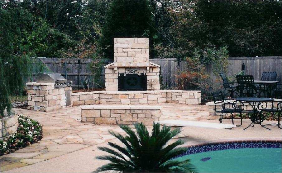 Stacked-stone outdoor fireplace and seating area beside a pool