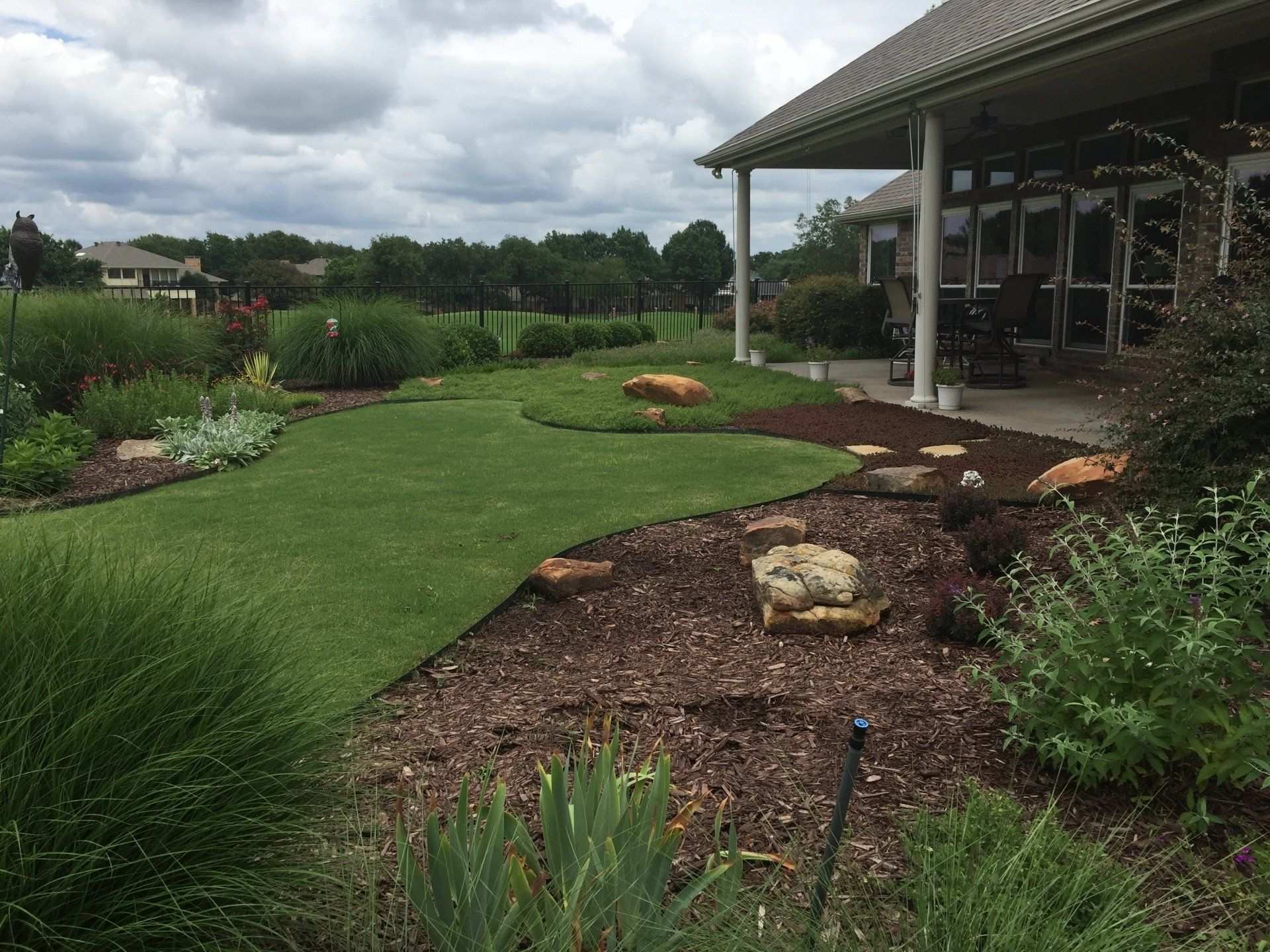 Newly planted bed and lawn behind a covered patio